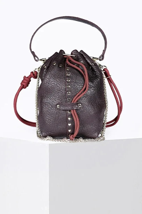 Purple leather handbag with red accents on a white background