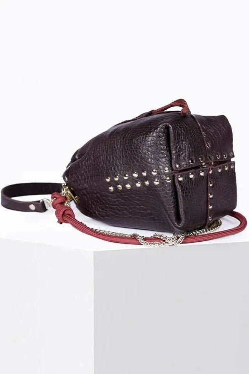 Dark brown leather bag with studs on a white background